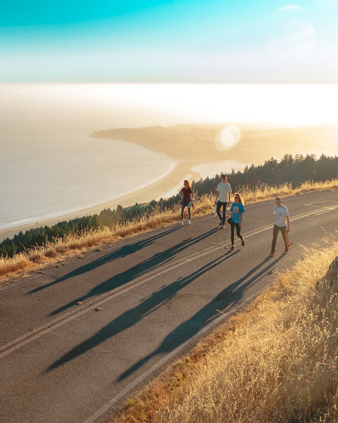 four-men-and-women-walking-on-roadway-near-body-of-water-8tnbgm3iu9o